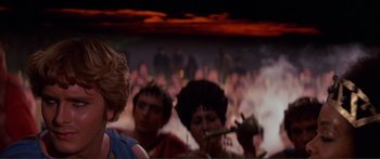 Movie still from “Fellini Satyricon” (1969), directed by Federico Fellini – A group of people sitting in front of an audience; Close Up shot, Over the shoulder angle