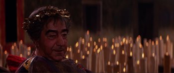 Movie still from “Fellini Satyricon” (1969), directed by Federico Fellini – A person wearing a crown near candles; Close Up shot, High angle