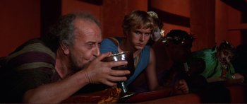 Movie still from “Fellini Satyricon” (1969), directed by Federico Fellini – A man and a woman sitting at a dinner table; Close Up shot, Over the shoulder angle