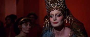 Movie still from “Fellini Satyricon” (1969), directed by Federico Fellini – A woman with a crown and a blue dress on; Close Up shot, Over the shoulder angle