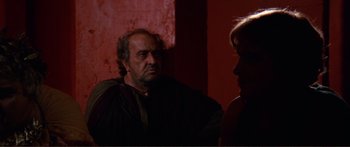 Movie still from “Fellini Satyricon” (1969), directed by Federico Fellini – A man and a woman are talking in a dark room; Medium shot, Over the shoulder angle