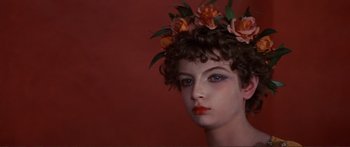 Movie still from “Fellini Satyricon” (1969), directed by Federico Fellini – A woman with a flower crown on her head; Close Up shot, High angle