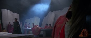 Movie still from “Fellini Satyricon” (1969), directed by Federico Fellini – A group of people sitting around a table; Wide shot, High angle