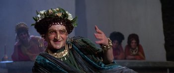 Movie still from “Fellini Satyricon” (1969), directed by Federico Fellini – An older woman dressed as a greek goddess; Close Up shot, High angle