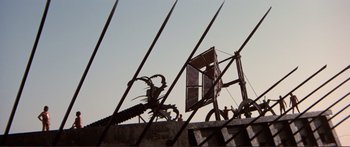 Movie still from “Fellini Satyricon” (1969), directed by Federico Fellini – A metal sculpture of a scorpion on top of a building; Extreme Wide shot, Low angle