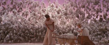 Movie still from “Fellini Satyricon” (1969), directed by Federico Fellini – A woman in a white dress pulling a white dog on a cart; Wide shot, High angle