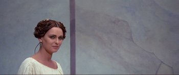 Movie still from “Fellini Satyricon” (1969), directed by Federico Fellini – A painting of a woman in front of a white wall; Close Up shot, Over the shoulder angle