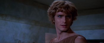 Movie still from “Fellini Satyricon” (1969), directed by Federico Fellini – A person wearing a brown shirt; Close Up shot, Over the shoulder angle