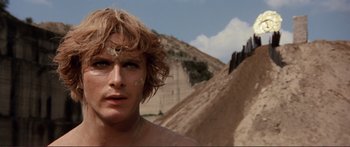 Movie still from “Fellini Satyricon” (1969), directed by Federico Fellini – A person with a mountain in the background; Close Up shot, Low angle
