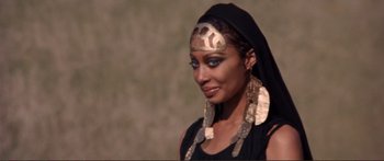 Movie still from “Fellini Satyricon” (1969), directed by Federico Fellini – A woman in a headpiece and a black dress; Close Up shot, Over the shoulder angle