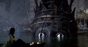 Movie still from “Fellini's Casanova” (1976), directed by Federico Fellini – A boat floating on top of a body of water next to a building; Extreme Wide shot, Low angle