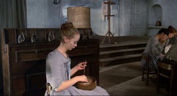 Movie still from “Fellini's Casanova” (1976), directed by Federico Fellini – A young girl sitting on a chair and sewing a basket; Medium shot, High angle