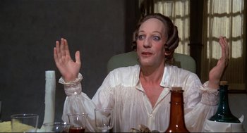 Movie still from “Fellini's Casanova” (1976), directed by Federico Fellini – A woman in a white shirt sitting in front of a table; Close Up shot, Over the shoulder angle