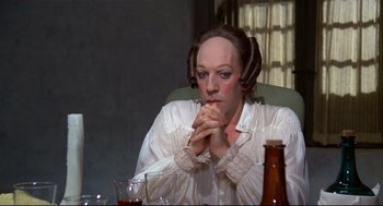 Movie still from “Fellini's Casanova” (1976), directed by Federico Fellini – A woman sitting in front of a table with two beer bottles; Close Up shot, High angle
