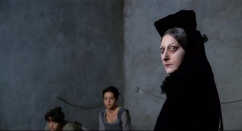 Movie still from “Fellini's Casanova” (1976), directed by Federico Fellini – A woman dressed as a witch in front of another woman; Close Up shot, Over the shoulder angle