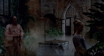 Movie still from “Fellini's Casanova” (1976), directed by Federico Fellini – A woman standing in front of a fountain in front of a building; Wide shot, Low angle