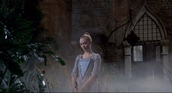 Movie still from “Fellini's Casanova” (1976), directed by Federico Fellini – A young woman standing in tall grass near a stone wall; Wide shot, Low angle