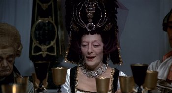 Movie still from “Fellini's Casanova” (1976), directed by Federico Fellini – A woman wearing a fancy headdress and a necklace; Close Up shot, Over the shoulder angle