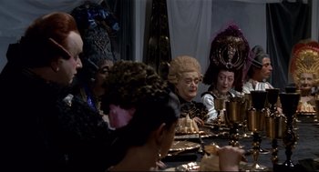 Movie still from “Fellini's Casanova” (1976), directed by Federico Fellini – A group of people sitting around a table; Medium shot, High angle