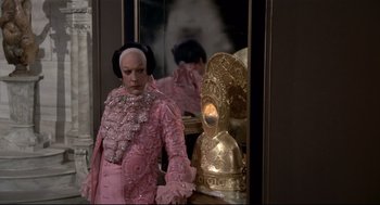 Movie still from “Fellini's Casanova” (1976), directed by Federico Fellini – A woman in a pink dress standing in front of a mirror; Medium shot, Over the shoulder angle