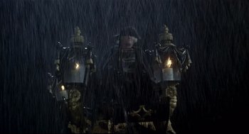 Movie still from “Fellini's Casanova” (1976), directed by Federico Fellini – A group of people standing in the rain with lit candles; Wide shot, Low angle