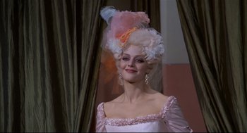 Movie still from “Fellini's Casanova” (1976), directed by Federico Fellini – A woman in a pink dress and a pink and white hat; Medium shot, Low angle