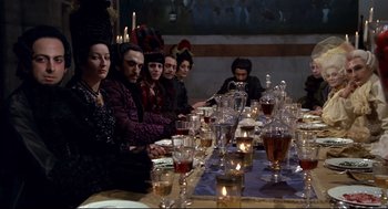 Movie still from “Fellini's Casanova” (1976), directed by Federico Fellini – A group of people sitting around a table with a lot of candles; Medium shot, High angle
