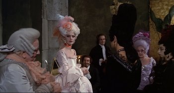 Movie still from “Fellini's Casanova” (1976), directed by Federico Fellini – A woman in a white dress and a pink and white hat; Medium shot, Over the shoulder angle