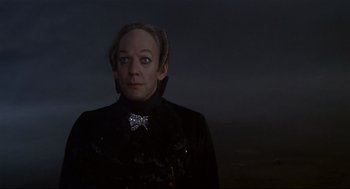 Movie still from “Fellini's Casanova” (1976), directed by Federico Fellini – A woman in a black jacket with a bow tie; Close Up shot, Low angle