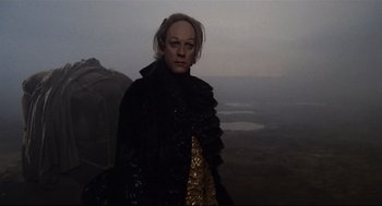 Movie still from “Fellini's Casanova” (1976), directed by Federico Fellini – A woman in a black jacket standing in a field; Medium shot, Low angle