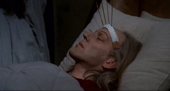 Movie still from “Fellini's Casanova” (1976), directed by Federico Fellini – A man is laying in a bed with acupuncture needles on his head; Close Up shot, High angle