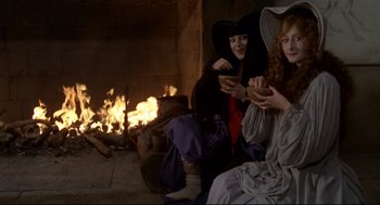 Movie still from “Fellini's Casanova” (1976), directed by Federico Fellini – Two women dressed as witches sitting in front of a fireplace; Medium shot, High angle