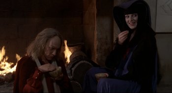 Movie still from “Fellini's Casanova” (1976), directed by Federico Fellini – Two people sitting in front of a fireplace; Medium shot, High angle