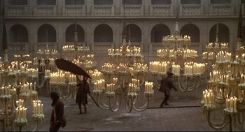 Movie still from “Fellini's Casanova” (1976), directed by Federico Fellini – A group of people standing around a room with a lot of lit candles; Extreme Wide shot, High angle