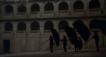 Movie still from “Fellini's Casanova” (1976), directed by Federico Fellini – A group of people holding umbrellas in the rain; Wide shot, High angle
