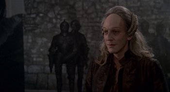 Movie still from “Fellini's Casanova” (1976), directed by Federico Fellini – A man with long blonde hair wearing a brown jacket; Close Up shot, Over the shoulder angle