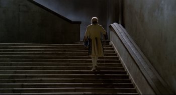 Movie still from “Fellini's Casanova” (1976), directed by Federico Fellini – An older man walking up a set of stairs with a cane; Wide shot, Low angle