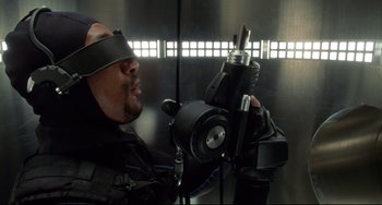 Movie still from “Femme Fatale” (2002), directed by Brian De Palma – A man holding a video camera in front of his face; Close Up shot, Overhead angle