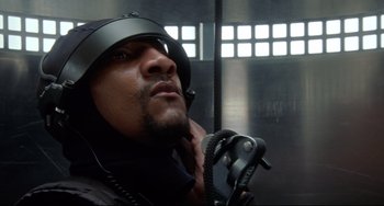 Movie still from “Femme Fatale” (2002), directed by Brian De Palma – A person wearing a helmet and talking on a phone; Close Up shot, Low angle