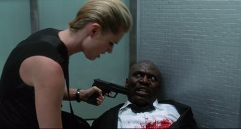 Movie still from “Femme Fatale” (2002), directed by Brian De Palma – A woman holding a gun up to a man's face; Medium shot, Low angle