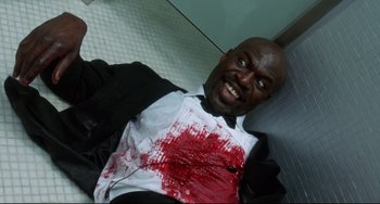 Movie still from “Femme Fatale” (2002), directed by Brian De Palma – A man in a black suit and white shirt with blood on his chest; Close Up shot, Overhead angle