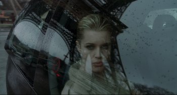 Movie still from “Femme Fatale” (2002), directed by Brian De Palma – A woman is looking out of a window at the eiffel tower; Close Up shot, Low angle