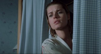 Movie still from “Femme Fatale” (2002), directed by Brian De Palma – A woman with wet hair standing in front of a curtain; Close Up shot, Low angle