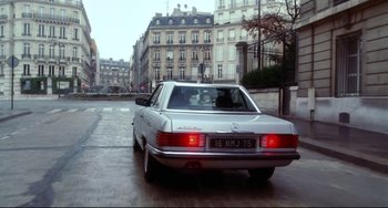 Movie still from “Femme Fatale” (2002), directed by Brian De Palma – A car driving down a street past tall buildings; Wide shot, Low angle