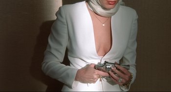 Movie still from “Femme Fatale” (2002), directed by Brian De Palma – A woman in a white dress holding a camera; Close Up shot, High angle