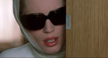Movie still from “Femme Fatale” (2002), directed by Brian De Palma – A person wearing sunglasses; Close Up shot, Low angle