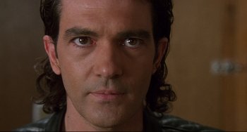 Movie still from “Femme Fatale” (2002), directed by Brian De Palma – Close up of a man with long black hair; Close Up shot, Low angle