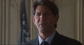 Movie still from “Femme Fatale” (2002), directed by Brian De Palma – A person wearing a suit and tie; Close Up shot, Over the shoulder angle