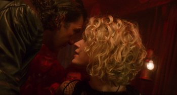 Movie still from “Femme Fatale” (2002), directed by Brian De Palma – A woman and a man are kissing in a room; Close Up shot, Over the shoulder angle