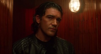 Movie still from “Femme Fatale” (2002), directed by Brian De Palma – A person wearing a leather jacket; Close Up shot, Low angle